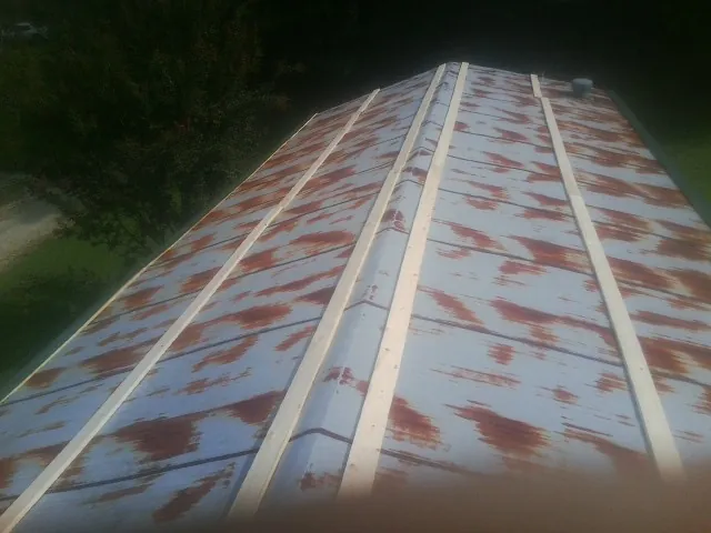 Rusted metal roof panels with new wood purlins before replacement — Storm Damage Roof Repair in Thayer by Roofing Brothers